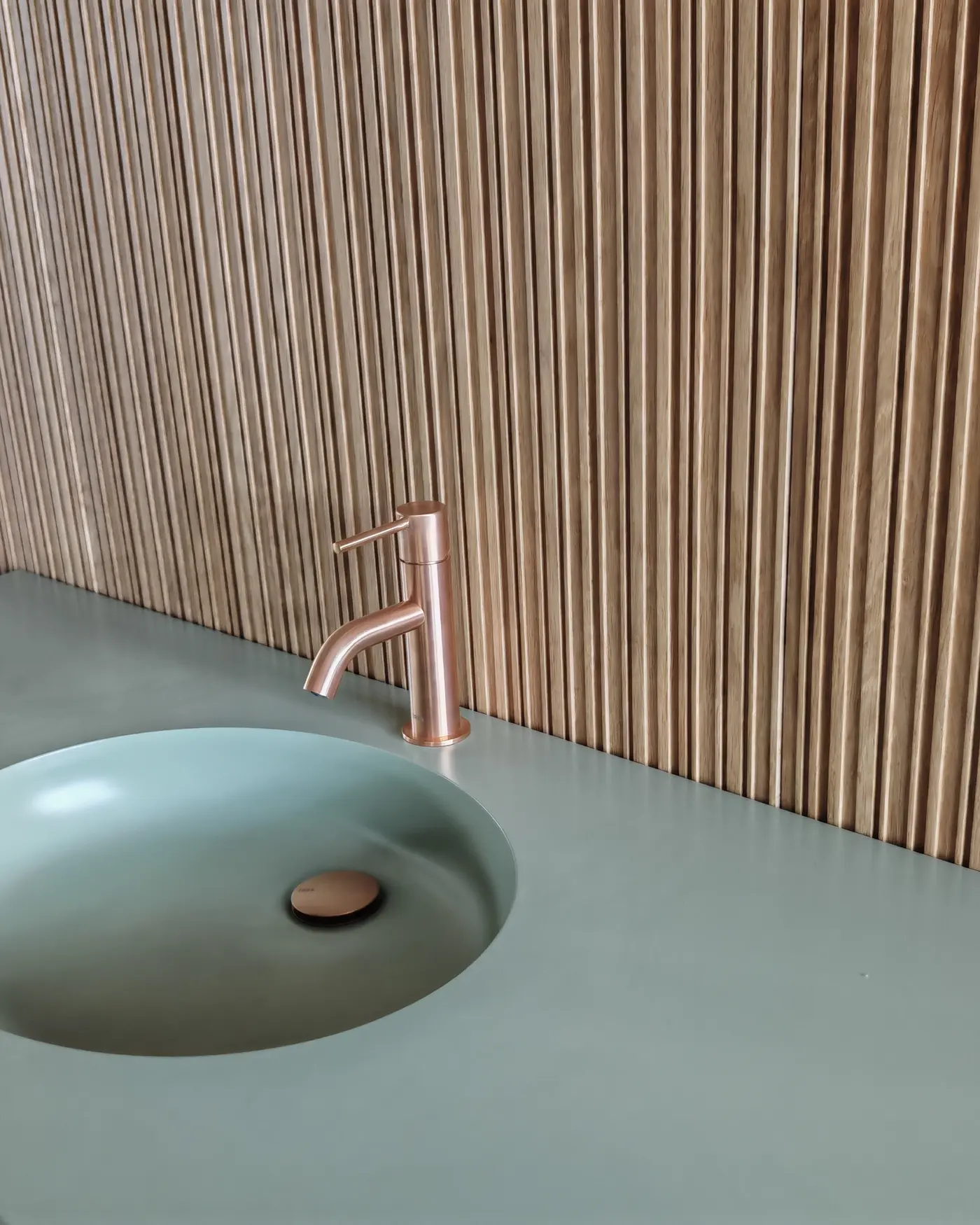 Detalle del lavabo integrado y grifería en cobre